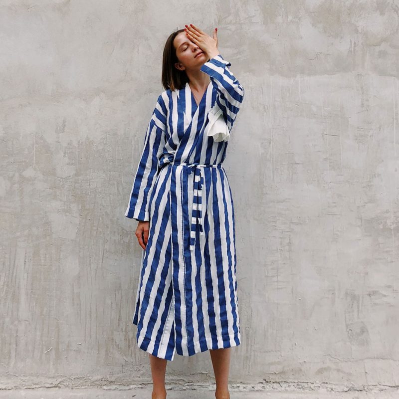 woman-in-blue-and-white-striped-dress-covering-her-left-eye-1182702